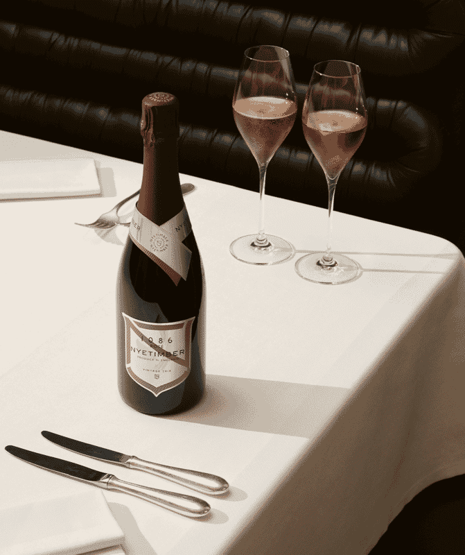 A bottle of Nyetimber 1086 Rosé 2013 on a table with two glasses poured